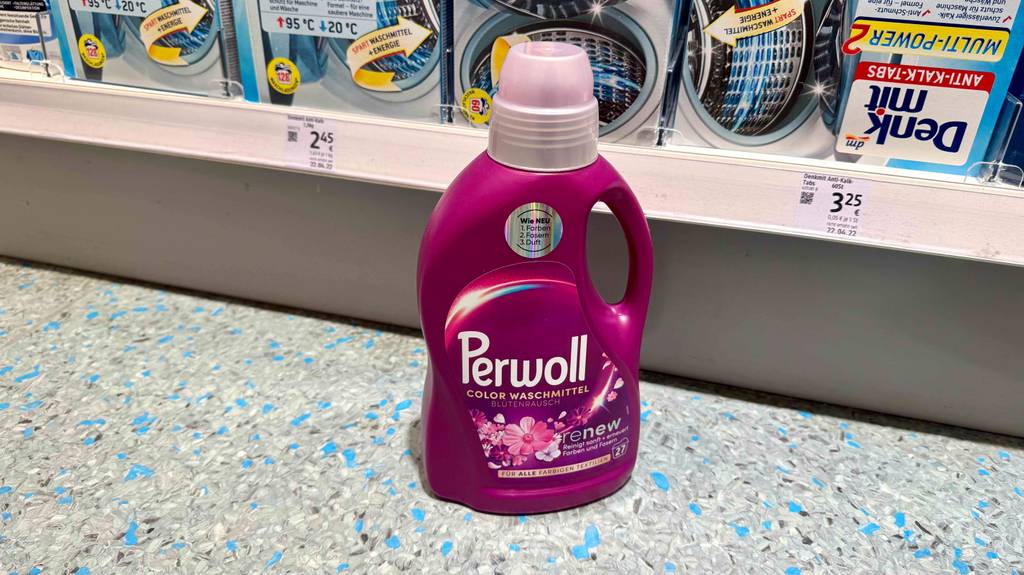 Im Test: Perwoll-Waschmittel in der Flasche steht auf dem Boden vor einem Verkaufsregal.