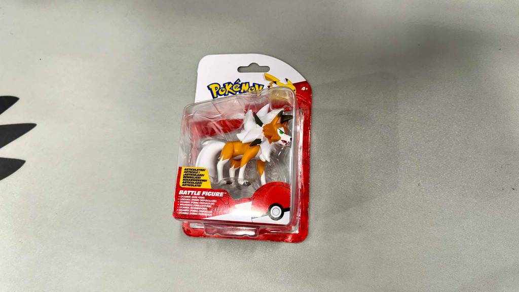 Eine Verpackung mit der getesteten Pokémon-Figur liegt auf dem Boden.
