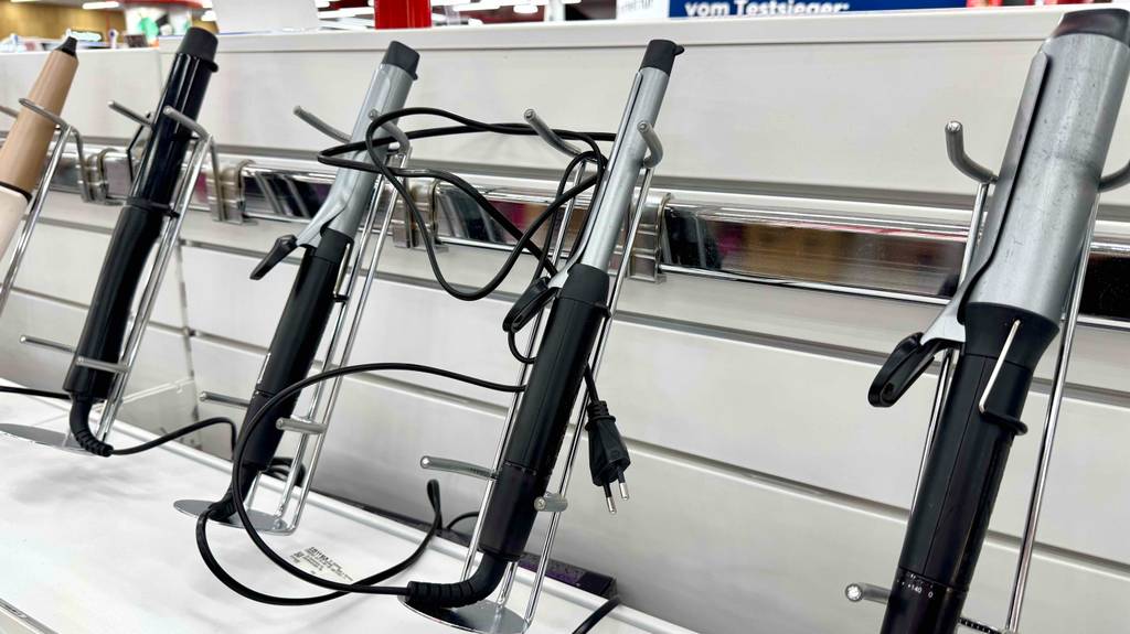 Der getestete Remington-Lockenstab ist neben weiteren Lockenstäben auf einem weißen Regal ausgestellt.