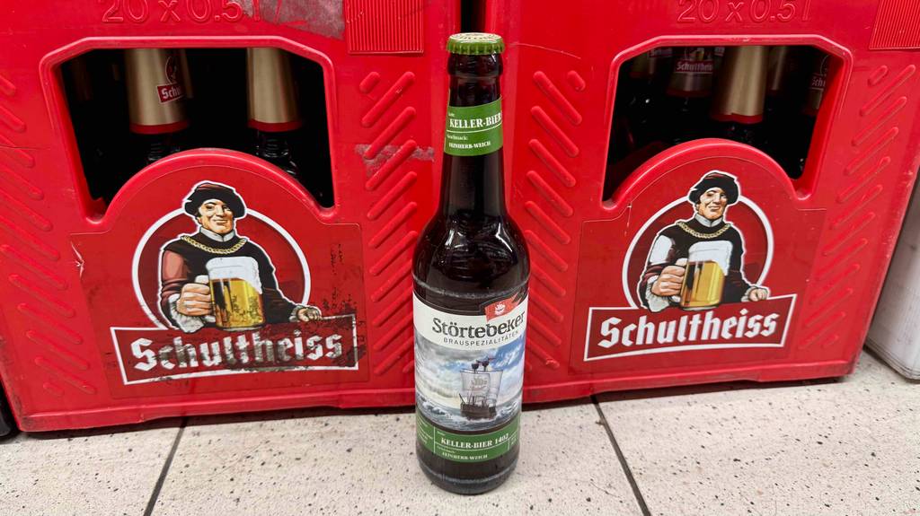 Getestet: Ein Störtebeker-Bier in der braunen Flasche steht vor zwei roten Bierkästen.