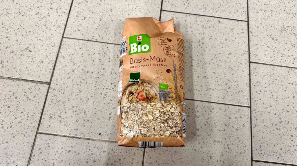 Im Test: Bio-Müsli in einer 750-g-Packung inklusive Sichtfenster, liegt auf einem Fliesenbelag.