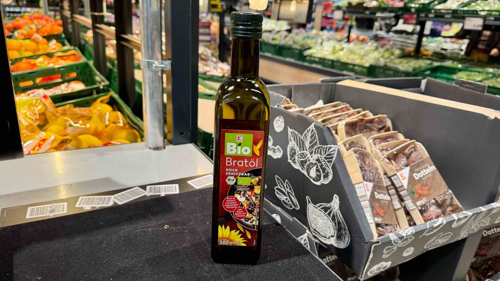 Das hocherhitzbare getestete kaltgepresste Öl befindet sich in einer 500-ml-Flasche, die im Supermarkt steht.