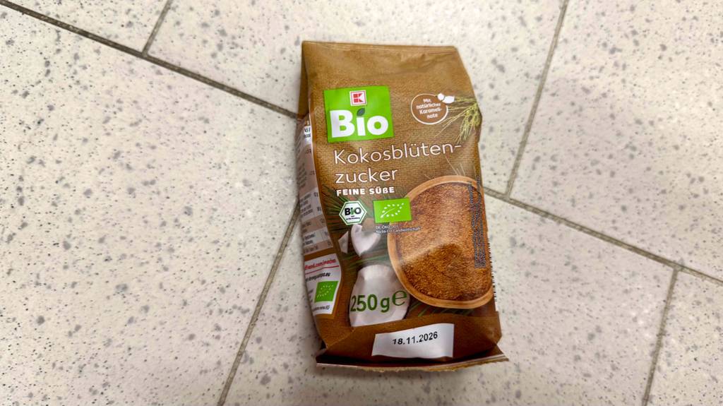 Getesteter Kokosblütenzucker in der 250-g-Packung liegt auf einem Fliesenboden.