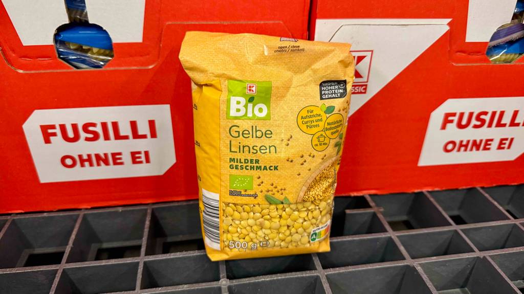 Eine Packung gelbe Linsen lehnt zum Testen an Nudelkartons.