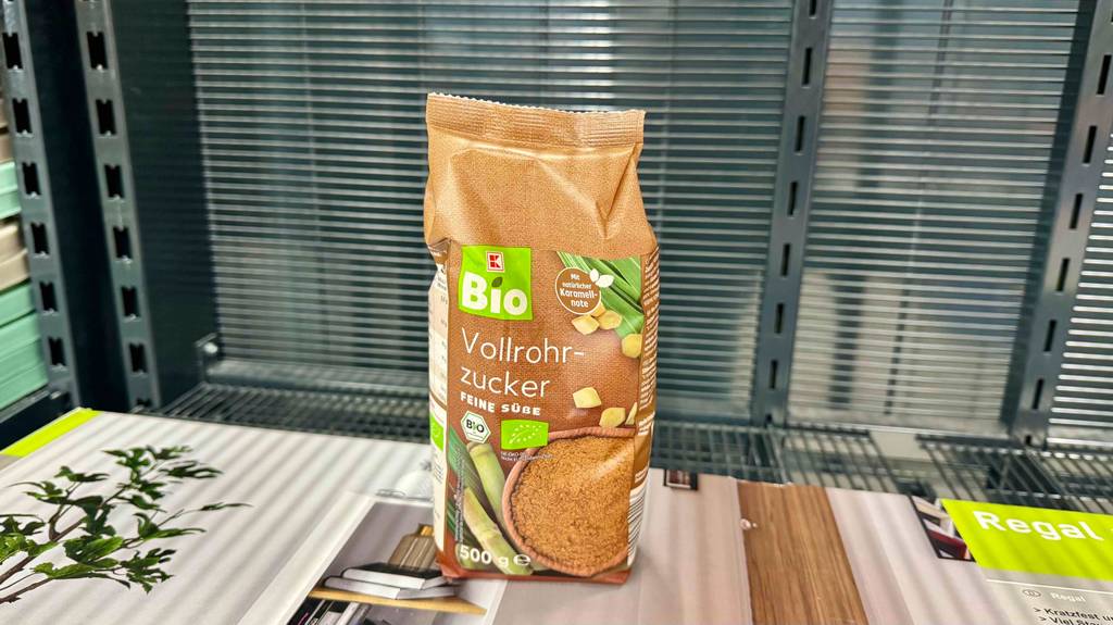 Eine Packung getesteter Vollrohrzucker steht auf einem Holzregal.