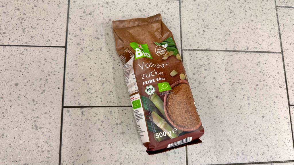 Eine Packung Vollrohrzucker liegt zum Testen auf Fliesen.
