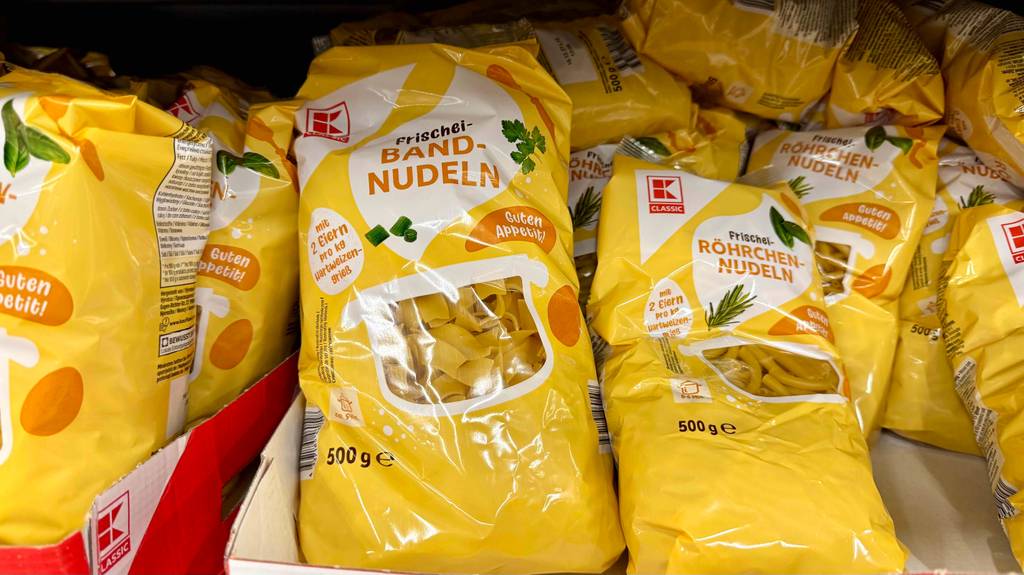 Mehrere gelbe 500-g-Packungen mit Bandnudeln im Test liegen nebeneinander auf einem Verkaufsregal.