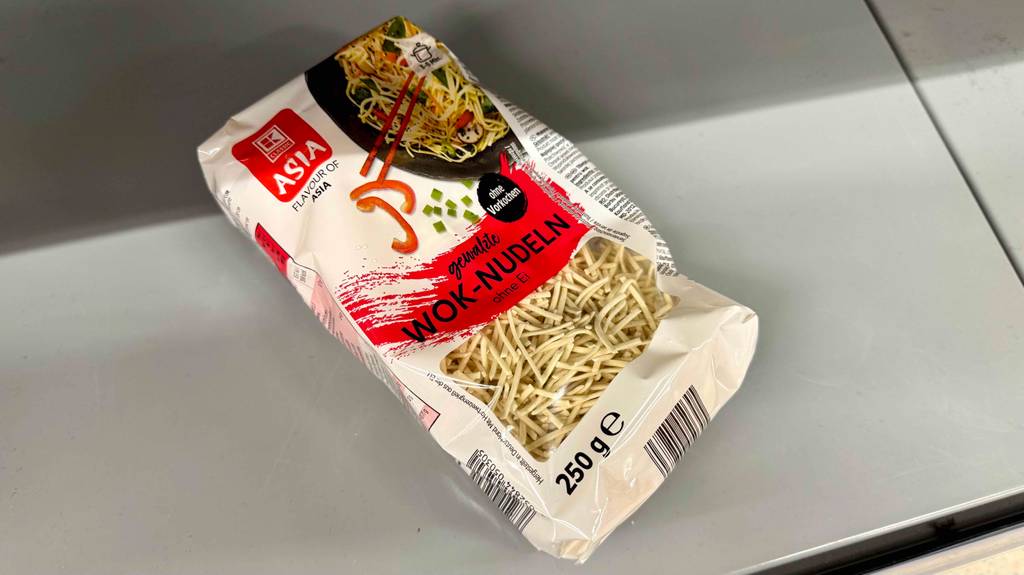 Eine 250-g-Packung inklusive getesteter Wok-Nudeln liegt auf einer weißen Oberfläche. Fliesenboden liegen.