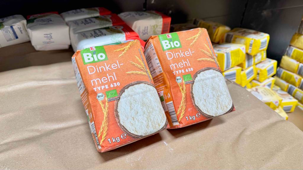 Getestet: Dinkelmehl 630 in zwei Packungen der Marke Kaufland liegen auf einer braunen Pappe vor weiteren Mehlsorten.