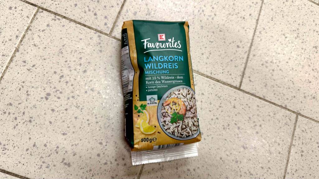 Eine Packung getesteter Wildreis liegt auf Fliesen.