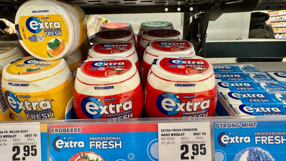 Mehrere Dosen des getesteten Kaugummis in einem Verkaufsregal mit Preisangaben.