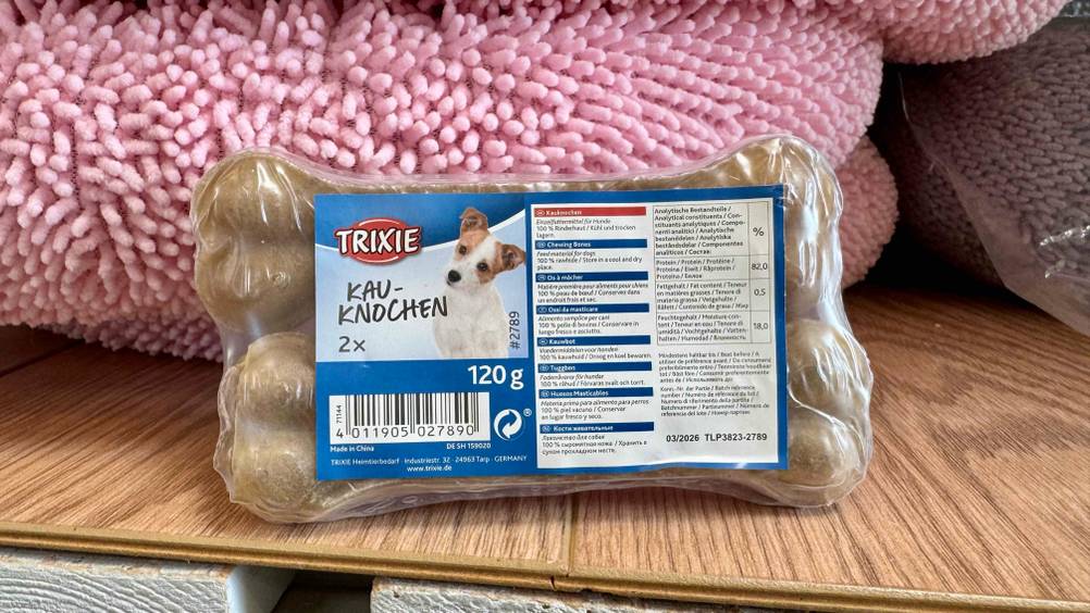 Vor einem rosa Hundebett steht eine Packung der getesteten Kauknochen Hund.