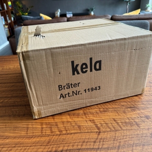 Der zusätzliche Karton des Kela Calido steht auf einem Tisch