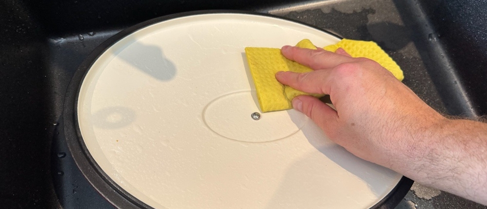 Der Deckel des Kela CALIDO wird von einer Hand mit einem Lappen gereinigt