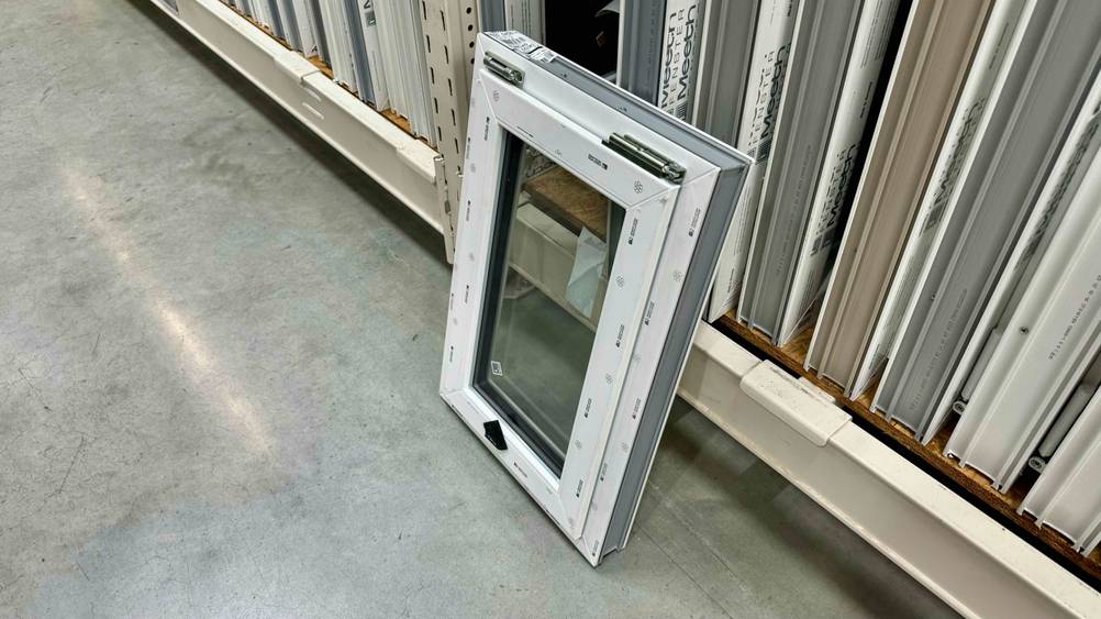 Ein Kellerfenster im Test lehnt an einem Verkaufsregal.