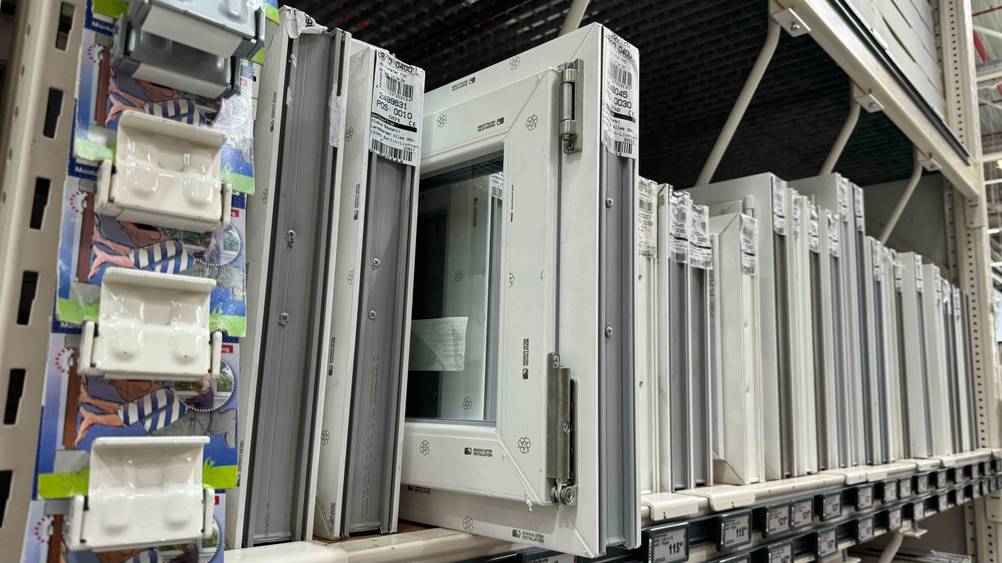 Nahaufnahme eines getesteten Kellerfensters mit Scharnieren zwischen mehreren anderen Fenster.