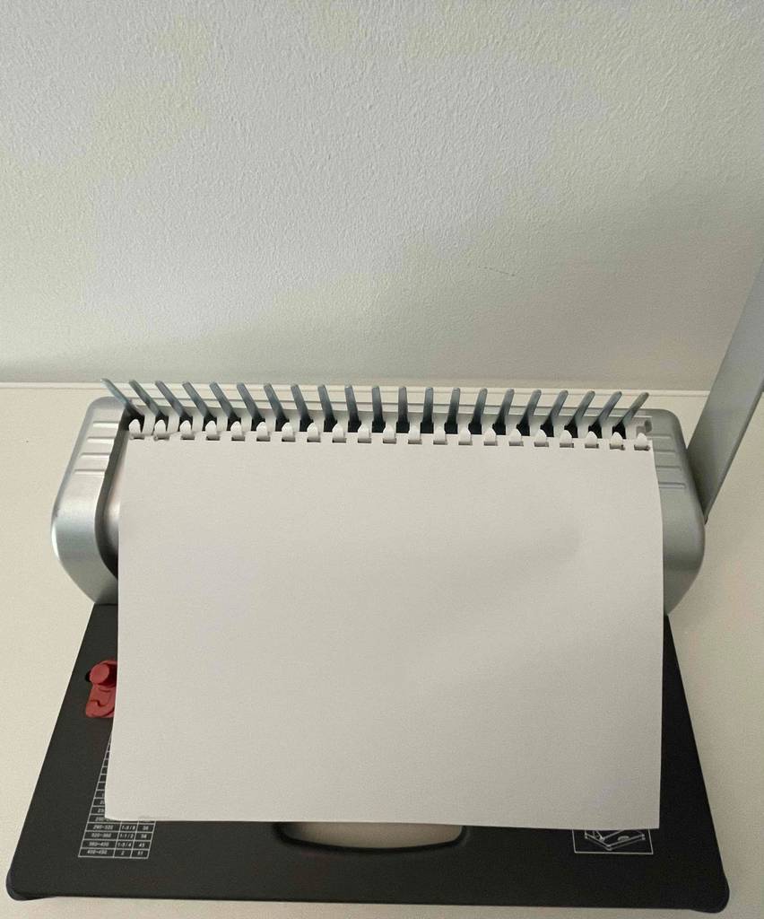 Kenley-Bindegrät-Test: A4-Blatt liegt in der Bindegerät-Vorrichtung für die Stanzung.