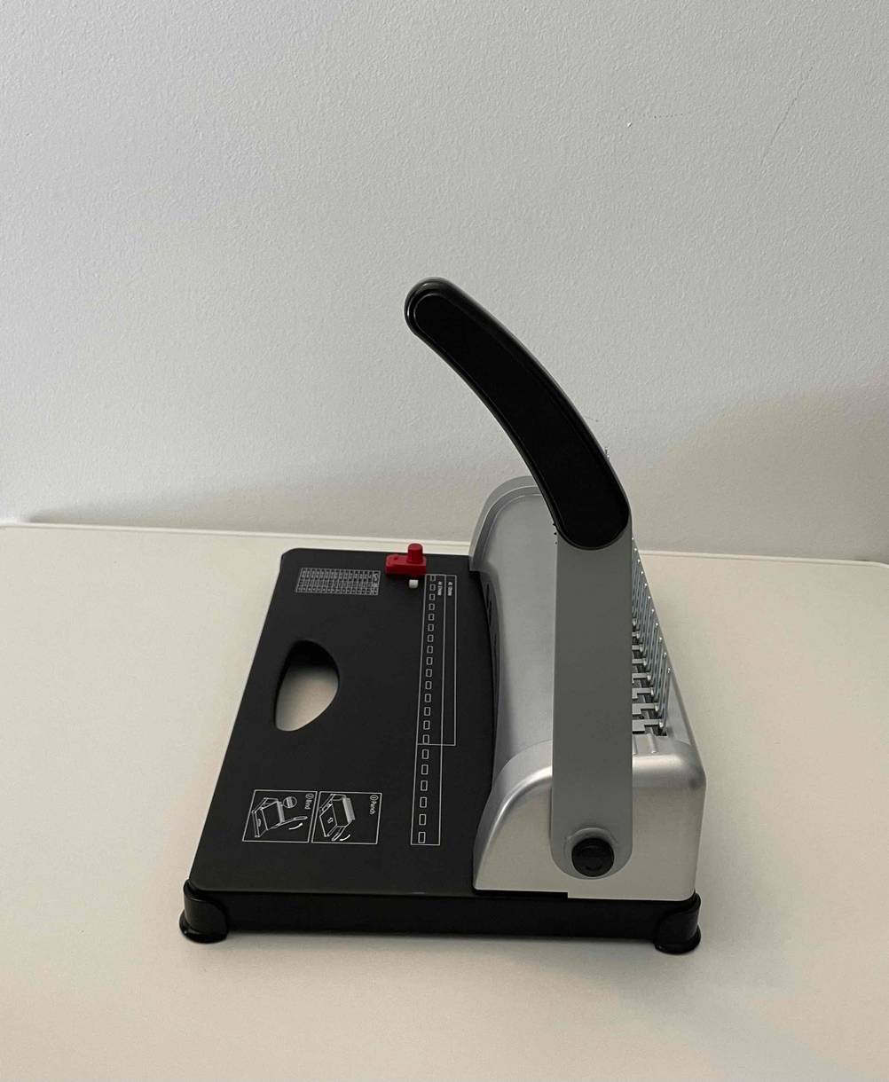 Seitenansicht eines mechanischen, getesteten Bindegeräts, das auf einem Tisch steht.