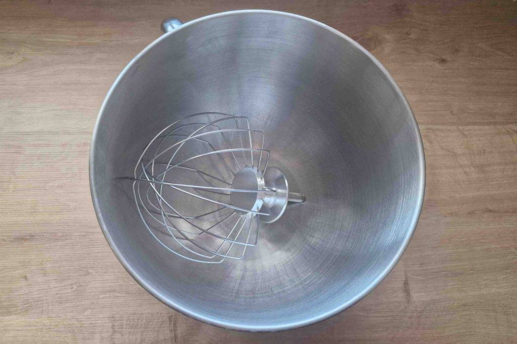 Schneebesen-Aufsatz liegt in der Rührschüssel aus Edelstahl einer getesteten Kenwood-Küchenmaschine.