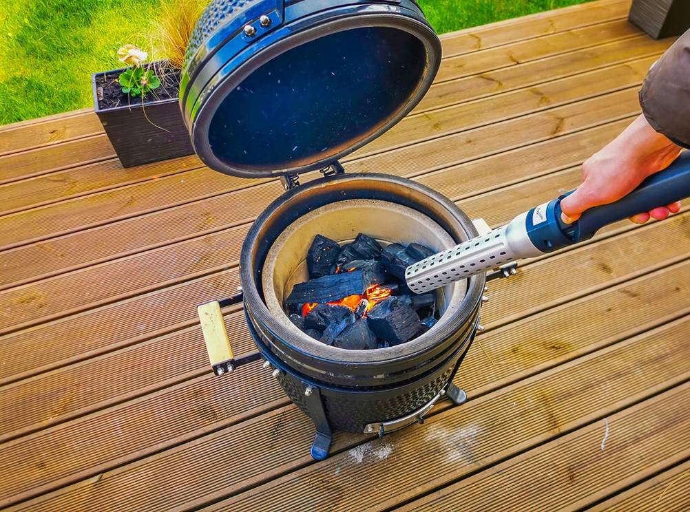 Kohle in einem Keramikgrill wird mit Hilfe eines elektrischen Kohleanzünders angezündet.