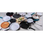 Mehrere Pfannen stehen um ein Schneidebrett mit Gemüse.