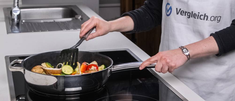 Gemüse wird in einer Keramikpfanne geschmort