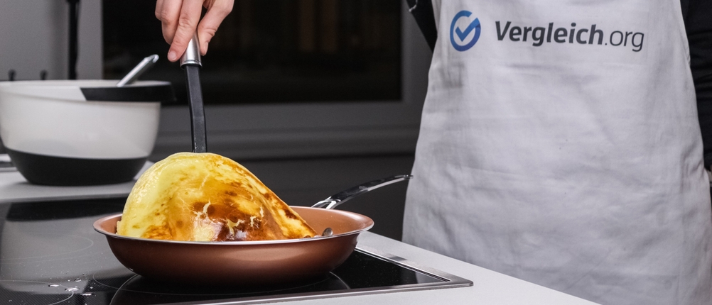 Ein Pfannkuchen wird in einer Pfanne gewendet.