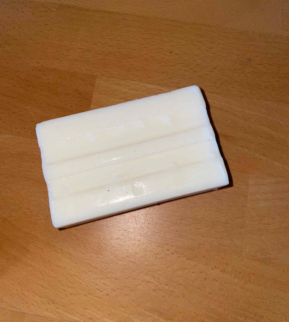 Ein Stück weiße Kernseife liegt auf dem Tisch.