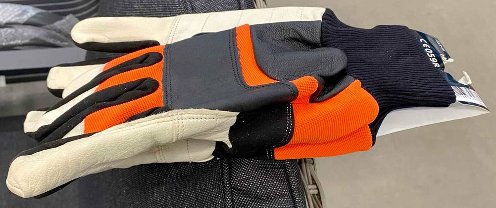 Nahaufnahme von Arbeitshandschuhen im Test in orange-weiß-schwarzer Ausführung.