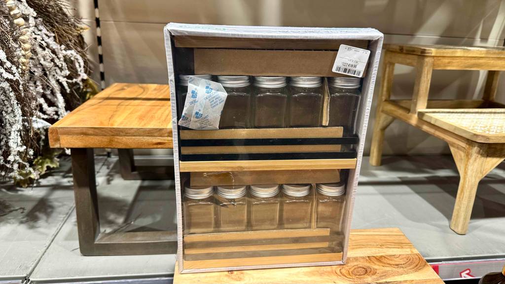Getestet: Ein Gewürzregal mit zehn leeren Gewürzdosen aus Glas steht eingepackt neben Kleinmöbeln.