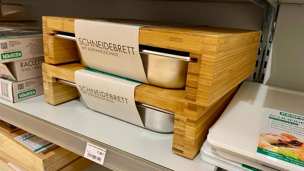 Zwei der getesteten Schneidebretter mit Auffangschale stehen aufeinander.