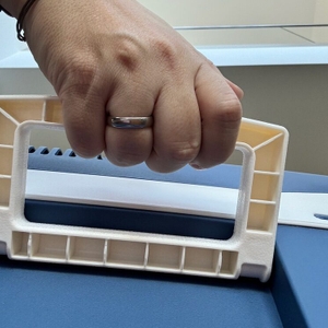 Eine Hand hält den Griff der Kesser-Kühlbox mit Rädern fest.