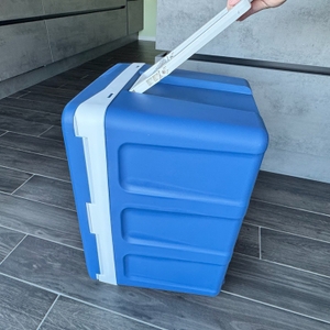 Der große Griff der Kesser-Kühlbox mit Rädern wird von einer Hand gehalten.