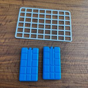 Das Zubehör der Kesser-Kühlbox mit Rädern liegt auf einem Tisch.
