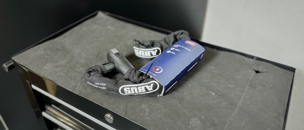 Das Kettenschloss von Abus liegt eingepackt auf einem Rollwagen.