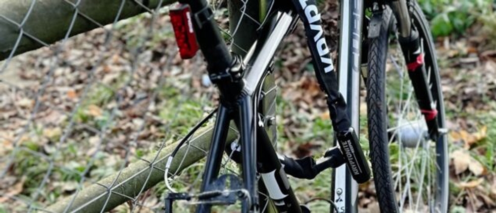 Ein Fahrrad wurde mit dem Kettenschloss von Kryptonite an einen Zaun angeschlossen.