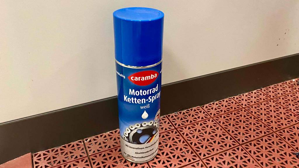 Getestetes Kettenspray befindet sich in einer Kunststoffdose auf dem Boden. 