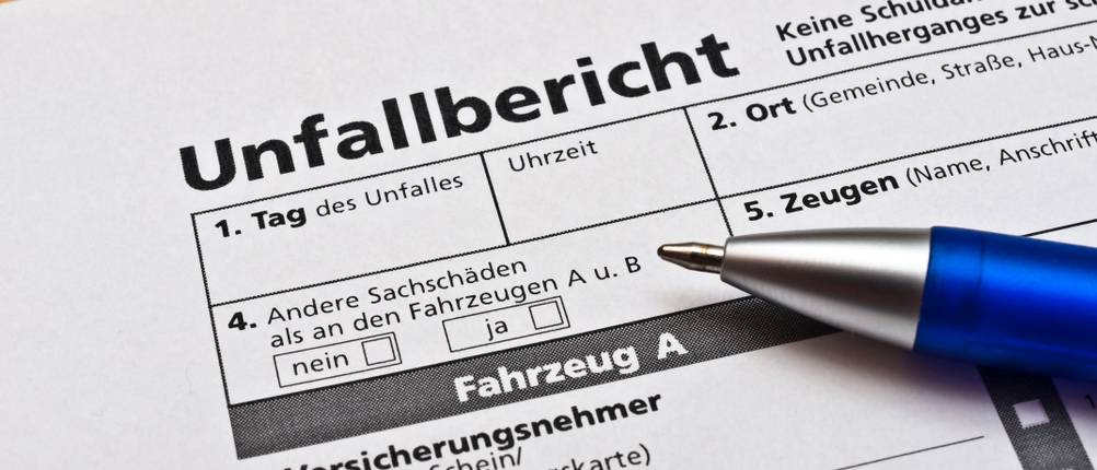 Kfz-Versicherungen getestet: Ein Kugelschreiber liegt auf einem Unfallbericht.
