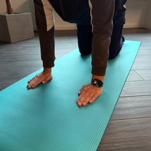 Auf der Kg-Physio-Yogamatte macht eine Person eine Übung