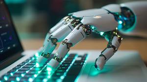 KI-Text-Generatoren im Test: Eine Roboterhand schreibt auf der Tastatur eines Laptops.