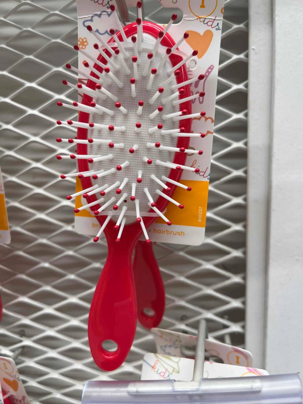 Im Test: Rote Kinder-Haarbürste hängt in einem Verkaufsregal.