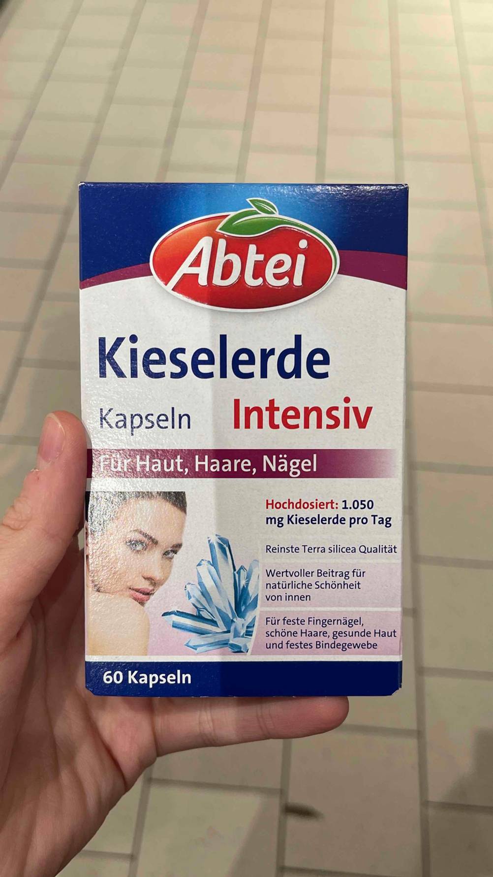 Die Packung der Kieselerde-Kapseln im Test von vorne von einer Hand gehalten.