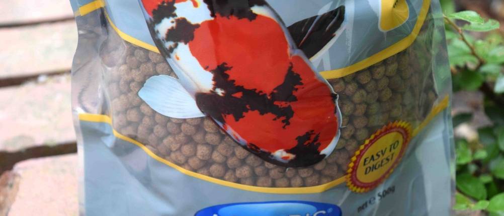 Eine Tüte Koifutter, ein großer Koi ist abgebildet.