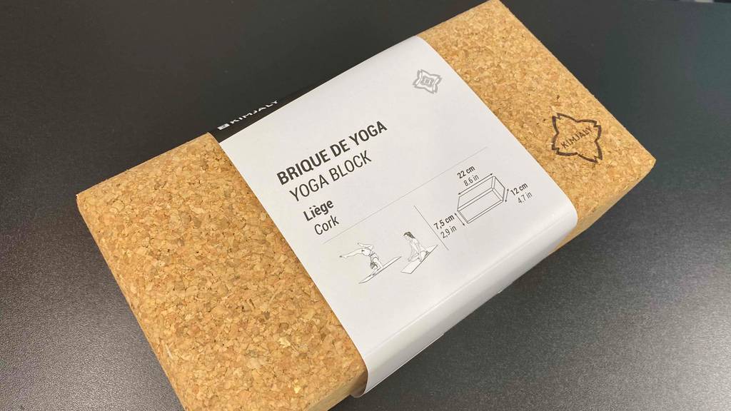 Ein Yogablock schräg auf einem dunklen Untergrund.