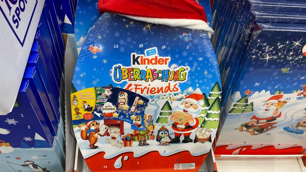 Ein Kinder-Adventskalenders ist zum Test bereit. Er steht inklusive Nikolaus-Zipfelmütze aus rotem Plüsch mit weißem Rand im Verkaufsregal.
