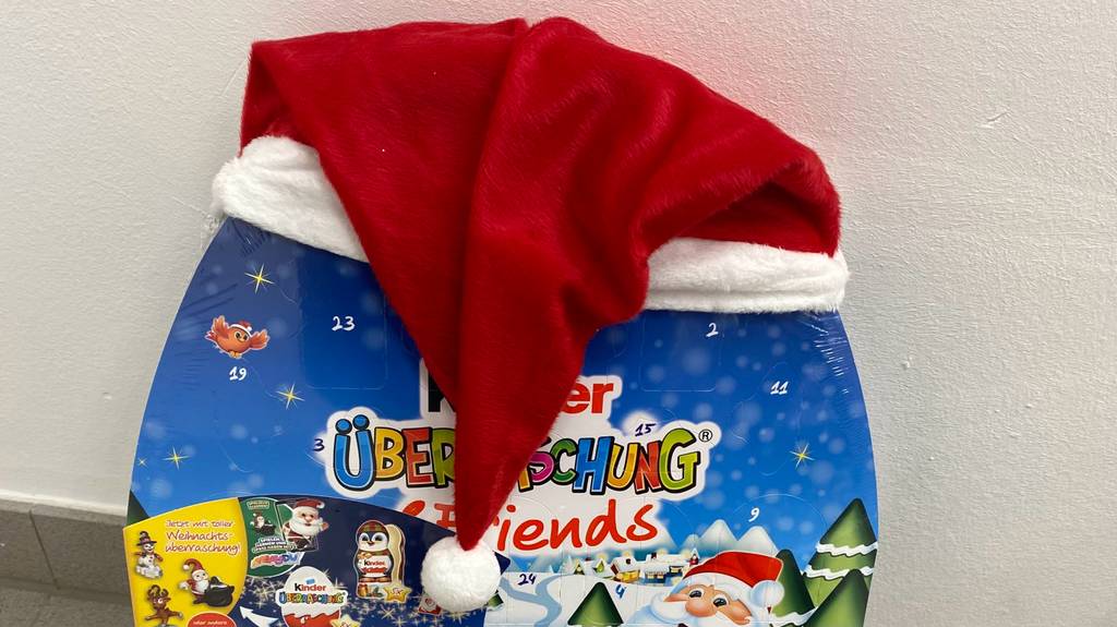 Ansicht des oberen Bereichs des Kinder-Adventskalenders im Test mit Nikolaus-Zipfelmütze aus rotem Plüsch mit weißem Rand und Bommel.