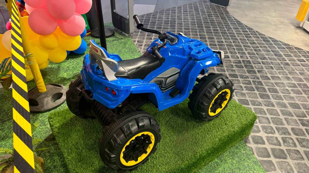 Kinder-Elektro-Quad im Test: Ein Kinder-Elektro-Quad von schräg hinten auf einem Kunstrasen.