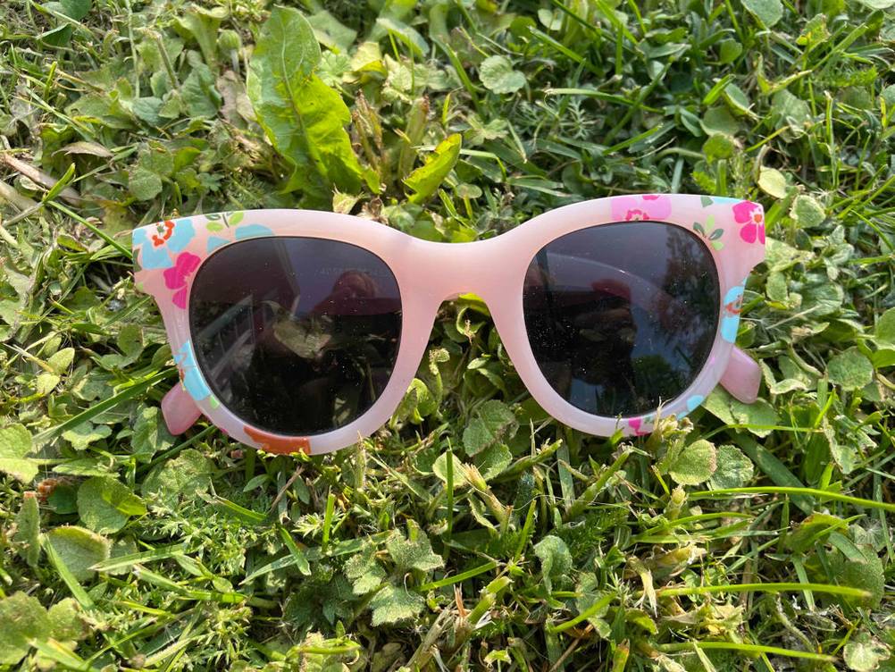 Auf einer Wiese liegt eine getestete Kinder-Sonnenbrille mit UV-Schutz.