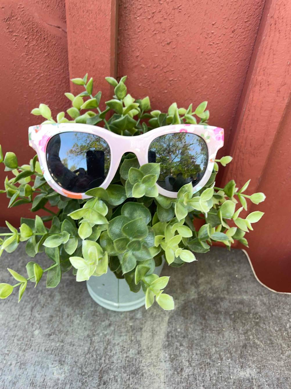 Auf einer Pflanze steht eine getestete Kinder-Sonnenbrille.