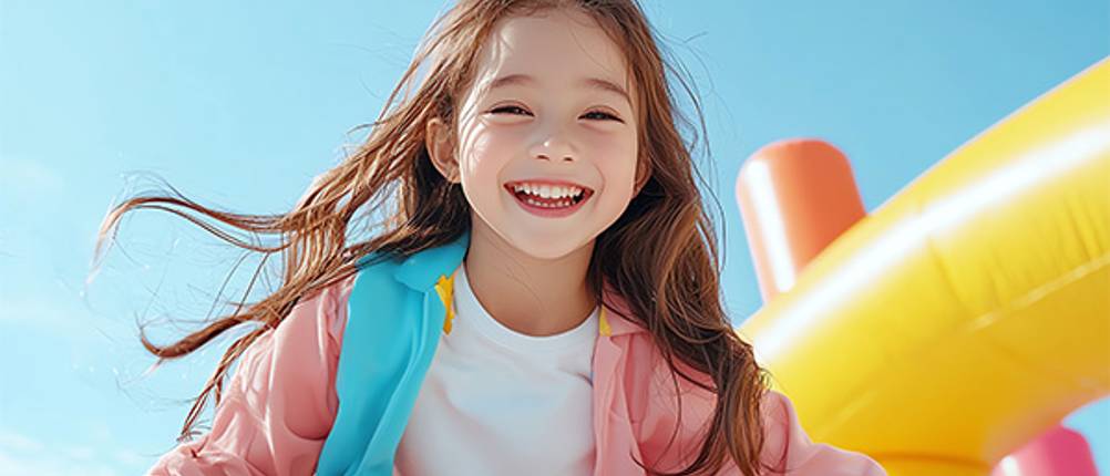 Kinder-Trainingsanzug im Test: Ein Mädchen in einem rosa, blau und gelben Trainingsanzug.